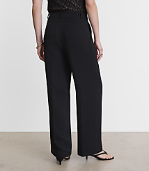 A person wearing black wide-leg pants and a patterned top stands against a plain, light-colored background. carousel Product Image 3