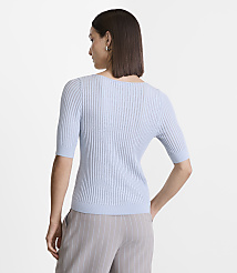 A woman in a light blue ribbed sweater and grey pinstripe pants stands against a plain white background. carousel Product Image 3