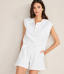 A woman in a white waffle-knit pajama set stands against a plain, light-colored wall. carousel Product Image 3
