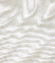 A white waffle-knit fabric with soft folds fills the frame, creating a textured and gentle background. carousel Product Image 4