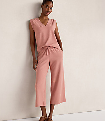 A woman in a pink loungewear set stands against a plain, light-colored wall. carousel Product Image 2