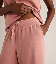 A person's torso is visible in the foreground, wearing a pink tank top and matching drawstring shorts, with a plain background. carousel Product Image 3