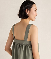 A woman with short dark hair wears a green dress with wide straps, set against a plain, light-colored background. carousel Product Image 3