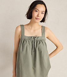 A young woman in a green top stands against a plain, light-colored background. carousel Product Image 1