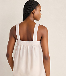 A woman with braided hair faces away from the camera, wearing a light-colored tank top against a plain, light background. carousel Product Image 3