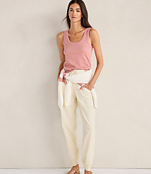 A woman in a pink tank top and cream pants stands against a textured, light-colored wall. carousel Product Image 2