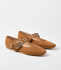A pair of brown suede Mary Jane flats with silver grommets and buckles rests on a plain white background. carousel Product Image 1