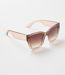 A pair of light brown, oversized sunglasses with gradient lenses rests on a plain white background. carousel Product Image 1