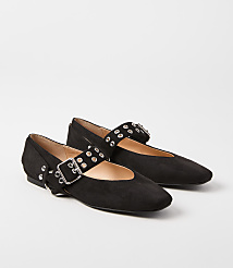 A pair of black suede ballet flats with silver buckle and stud detailing rests on a plain white background. carousel Product Image 1