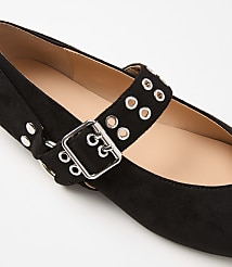 A black suede Mary Jane flat with a silver buckle and grommets is displayed against a plain white background. carousel Product Image 2