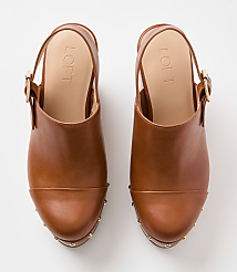 A pair of brown leather clogs with gold stud detailing are displayed against a plain white background. carousel Product Image 3