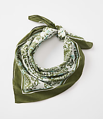 A green bandana with a white and green paisley pattern is tied in a knot against a plain white background. carousel Product Image 1