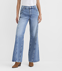 A person stands in light blue wide-leg jeans and brown boots against a plain white background. carousel Product Image 1