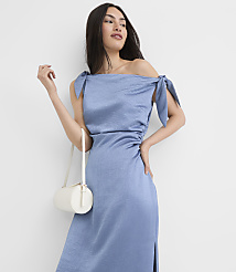 A woman in a blue off-the-shoulder dress with a white purse stands against a plain white background. carousel Product Image 1