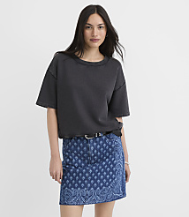 A woman in a dark t-shirt and patterned denim skirt stands against a plain white background. carousel Product Image 1
