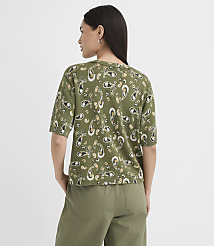 A woman in a green paisley-patterned shirt and olive pants stands against a plain white background. carousel Product Image 3