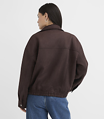 A woman in a brown jacket and blue jeans stands against a plain white background. carousel Product Image 3