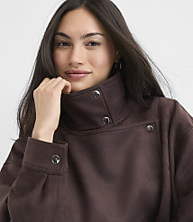 A woman in a brown mock-neck sweatshirt with silver snaps poses against a plain white background. carousel Product Image 4