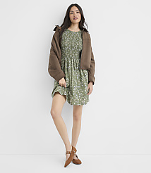 A woman in a floral dress and brown jacket stands against a plain white background. carousel Product Image 1