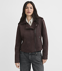 A woman in a brown suede moto jacket and jeans stands against a plain, light brown background. carousel Product Image 2