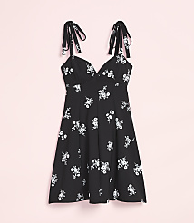 A black floral print dress with tie straps hangs against a soft pink background. carousel Product Image 4