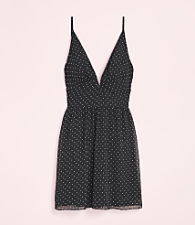 A black polka dot mini dress with thin straps is laid out against a soft pink background. carousel Product Image 4