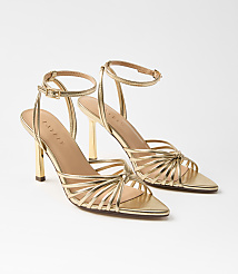 A pair of gold strappy high-heeled sandals with ankle straps are displayed against a plain white background. carousel Product Image 1