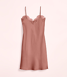 A coral-colored satin slip dress with lace trim hangs against a pale pink background. carousel Product Image 4