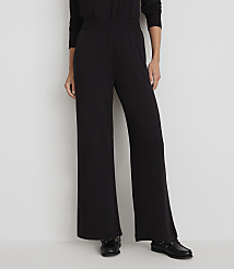 A person stands in wide-legged black pants and black shoes against a plain white background. carousel Product Image 2