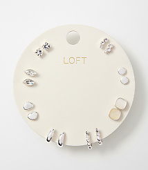 A circular white card displays a collection of assorted earrings, with the "LOFT" logo prominently featured in the center, against a plain white background. carousel Product Image 1