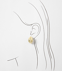 A gold oval earring with ribbed texture is worn on a sketched ear against a white background. carousel Product Image 2