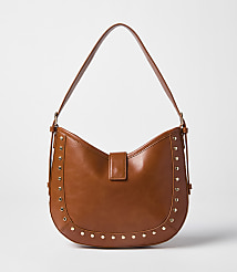 A brown leather hobo bag with gold stud accents rests against a plain white background. carousel Product Image 1