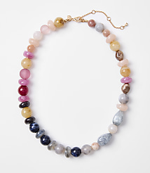 A colorful beaded necklace with various stones is laid out on a plain white background. carousel Product Image 1