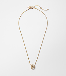 A delicate gold chain necklace with a stylized "D" pendant hangs against a plain white background. carousel Product Image 1