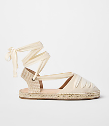 A cream-colored espadrille with ribbon ties is displayed against a plain white background. carousel Product Image 1