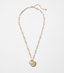 A gold necklace with two circular pendants rests on a plain white background. carousel Product Image 1