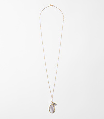 A delicate rose gold chain necklace with a pearlescent oval pendant and a small grey stone hangs against a plain white background. carousel Product Image 1