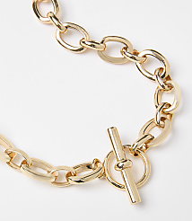 A chunky gold chain necklace with a toggle clasp lies on a plain white background. carousel Product Image 2