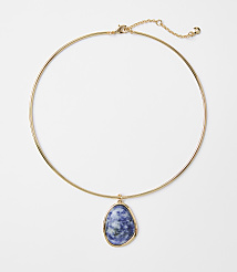 A gold choker necklace with a blue and white marbled stone pendant hangs against a plain white background. carousel Product Image 1