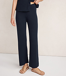A person wearing navy ribbed pants and tan sandals stands against a plain, light-colored background. carousel Product Image 2