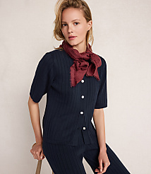 A woman in a navy ribbed cardigan and pants with a maroon scarf around her neck poses against a plain, light-colored background. carousel Product Image 3