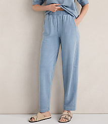 A person stands in light blue loungewear and sandals against a textured, light-colored wall. carousel Product Image 2