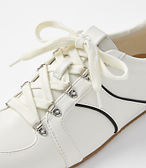 A white sneaker with cream laces is shown in close-up against a plain white background. carousel Product Image 2