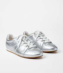 A pair of shiny silver sneakers with white laces rests on a plain white background. carousel Product Image 1