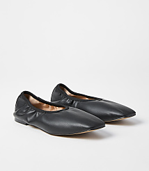 A pair of black leather ballet flats rests on a plain white background. carousel Product Image 1