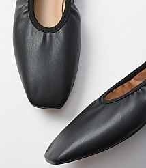 Two black leather ballet flats with gathered elastic trim are presented against a plain white background. carousel Product Image 2