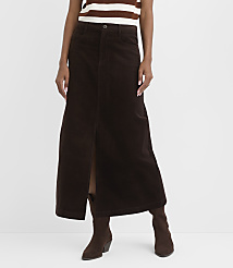 A woman in a brown corduroy maxi skirt with a front slit and brown boots stands against a plain white background. carousel Product Image 2