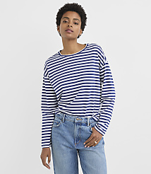 A woman in a striped long-sleeved shirt and jeans stands against a plain white background. carousel Product Image 1