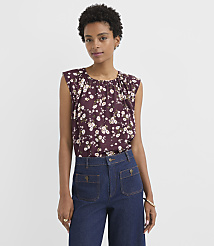 A woman in a floral top and dark denim pants stands against a plain white background. carousel Product Image 1
