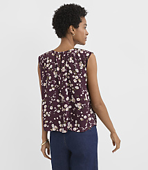 A woman in a floral top and jeans stands against a plain white background. carousel Product Image 3